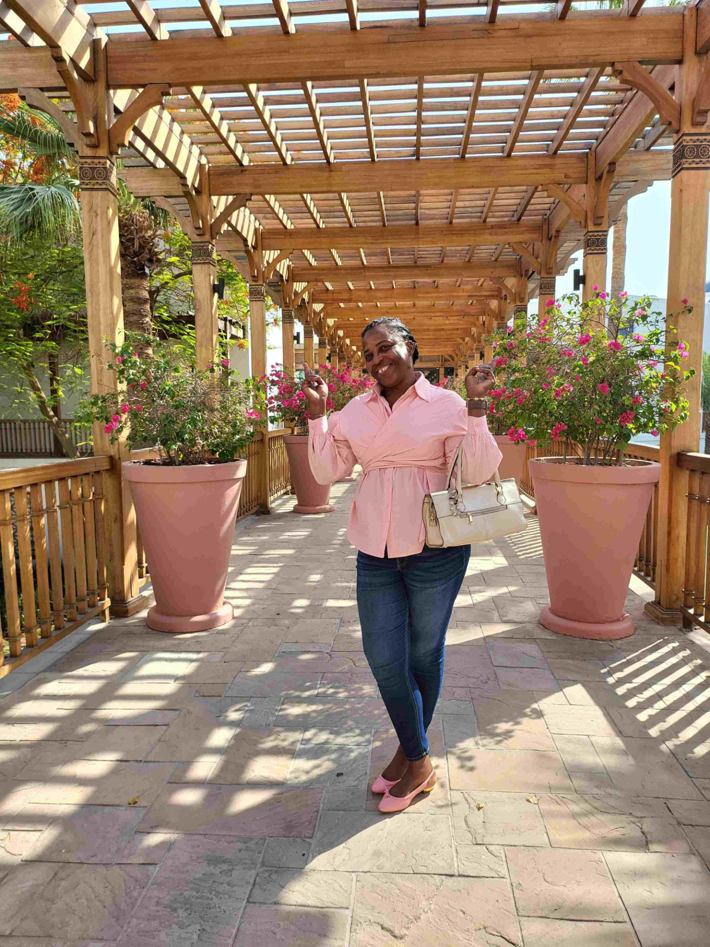 Josiane Djachechi standing beneath a shaded pergola walkway during a Dubai site review