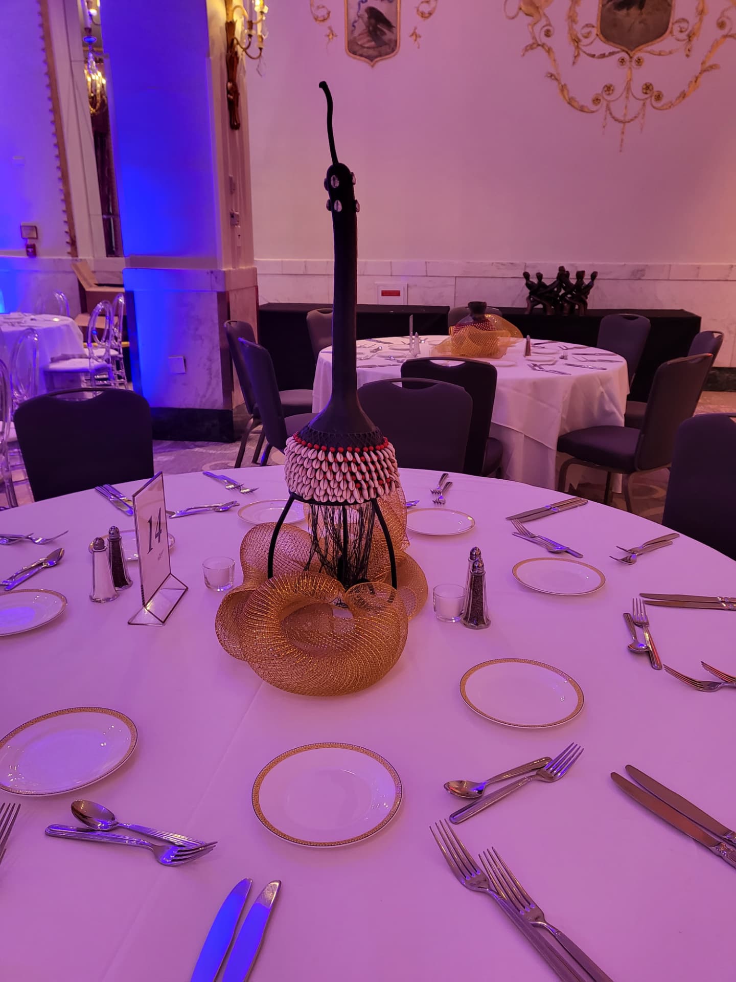 Cowrie-shell centerpiece and completed table setting at the International VIP Gala.