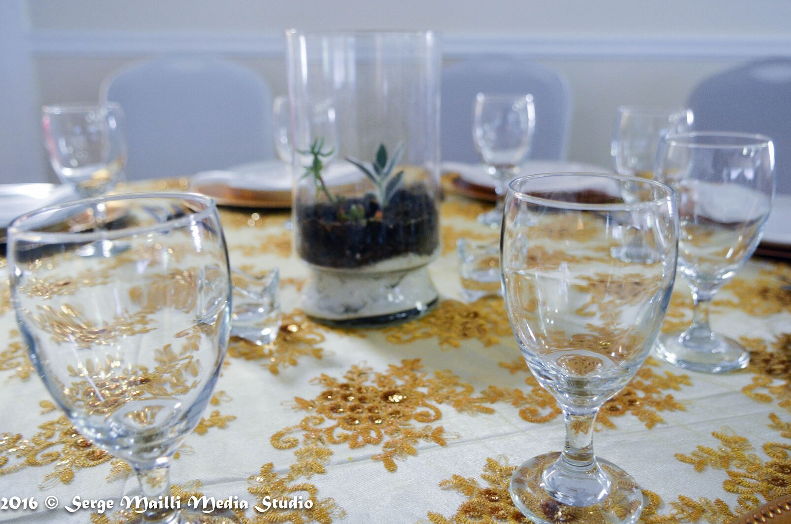 Handmade terrarium and living cactus set within the gold tablescape and glassware