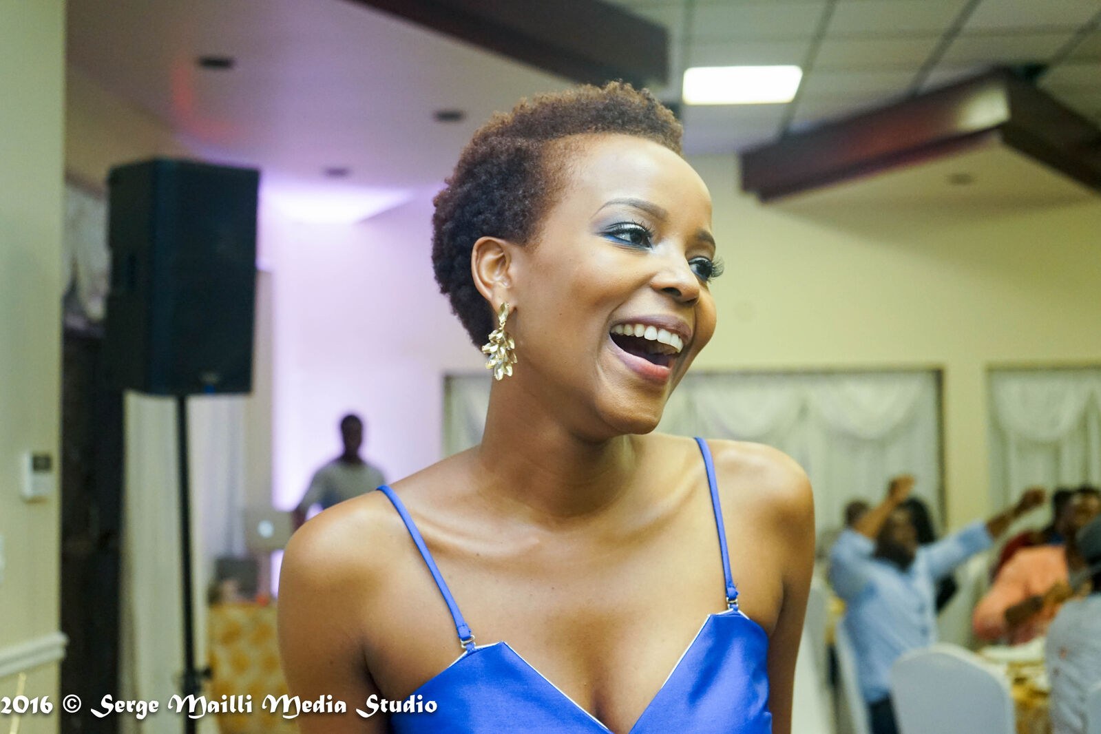 The graduate laughing during her celebration in a cobalt blue dress