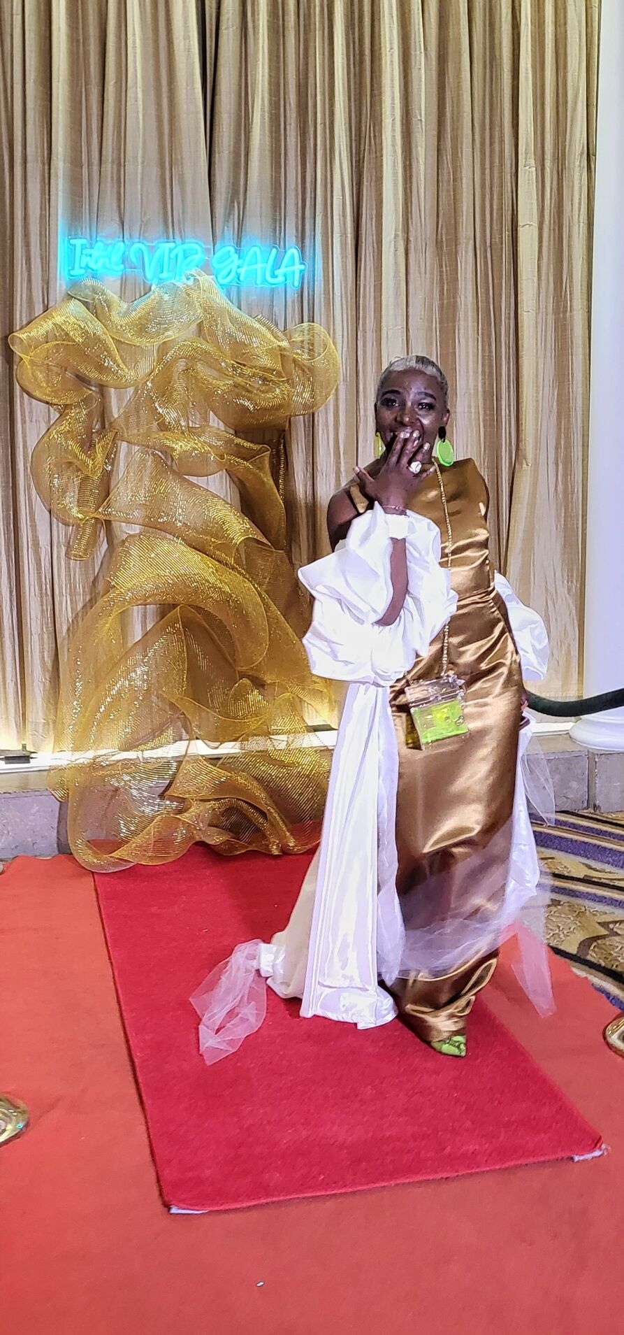 Founder of International VIPs standing beside the completed gold gala backdrop at The Mayflower Hotel in Washington, D.C.